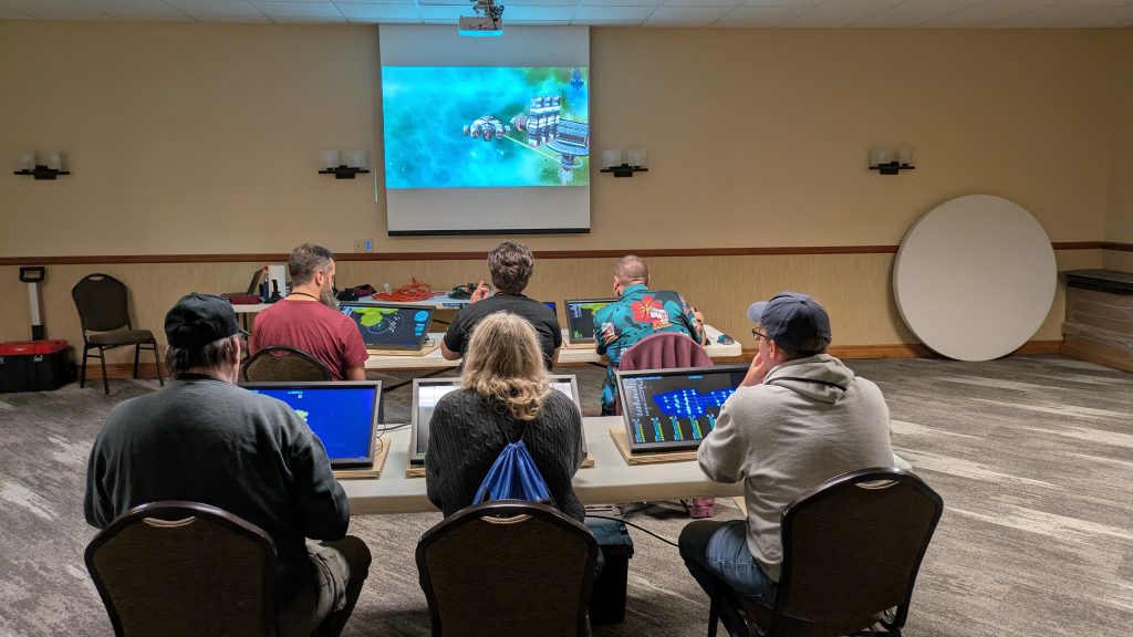 The full bridge with our main screen displaying the forward view during our mission to Winona Con 2025. Bridge stations, left to right, front row are Weapons, Captain, Helm and back row are Science, Communications and Engineering.